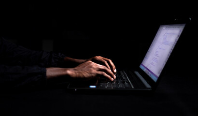 Black male hands typing on laptop