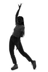 Silhouette of young woman in headphones dancing on white background
