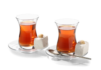 Glass cups of Turkish tea and sweets on white background