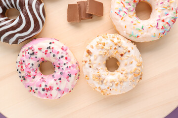 Wooden board of delicious donuts, closeup