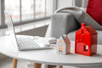 House candle holders, laptop and earphones on table in living room, closeup