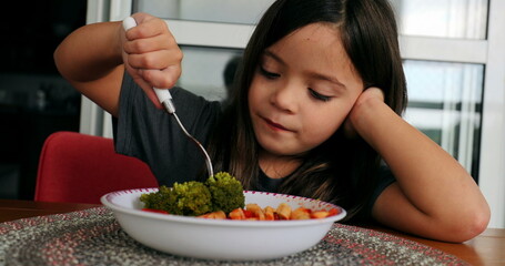 Kid eating broccoli small girl eats healthy vegetable for lunch