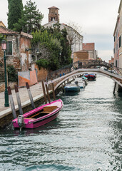 Fototapeta na wymiar pink boat docked on the canal in Venice, Italy