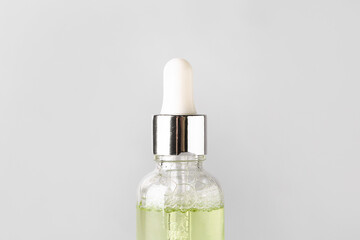 Naklejka premium Skincare serum dropper bottle with green liquid and bubbles, beauty product for facial treatment and hydration, this cosmetic item is essential for a daily skincare routine