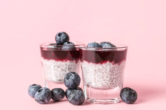 Shots of delicious pudding with chia seeds and blueberries on pink background