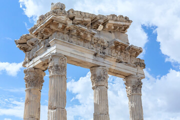 Fototapeta premium The Temple of Trajan in Pergamon Ancient City. Close up fragment of the entablature of the ruined temple with a stone-cut relief on the frieze. History, art or architecture concept. Bergama, Turkey