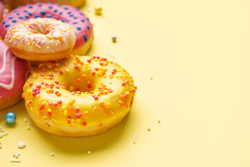 Tasty glazed donuts on yellow background, closeup
