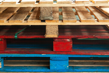 Multi-colored pallets stacked on top of each other.