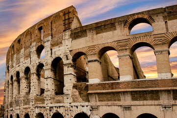 The Roman Colosseum at sunset highlighting the beautiful arches of this largest ancient...