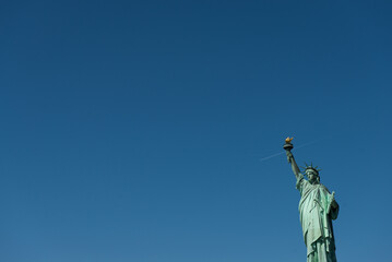 Statue of Liberty and blue skies and airplane jetstream - obrazy, fototapety, plakaty