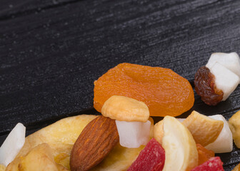 wooden background in retro style. a mixture of dried fruits lies on it. close-up. there is a tinting. soft focus.