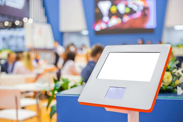 Electronic multimedia tablet kiosk with blank white display at exhibition, trade show, conference -...