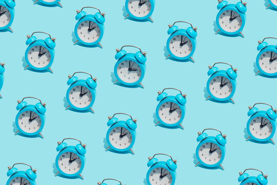 Seamless pattern of blue retro alarm clocks  show 2 o'clock and one shows 3. Changing clock from summer time to winter time. Shifting the clock hands back in autumn.