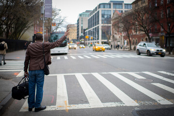 Person raising their arm to hail a yellow cab in New York City