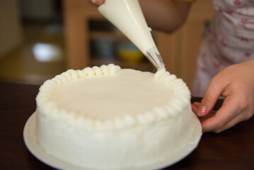 Fototapeta na wymiar Young asian girl baking birthday cake for her sister