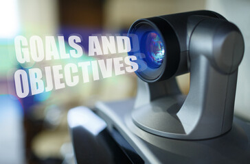 A blue beam glows from the projector inside which is the inscription - GOALS AND OBJECTIVES