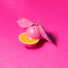 Monochromatic food concept. Tangerine on pink background. Minimalistic fruit composition. Creative summer nature idea.