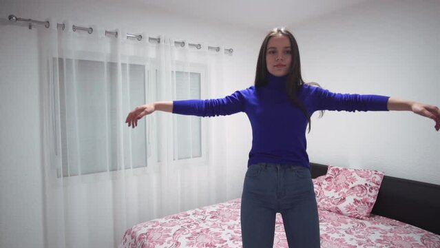 Happy teen is falling on the bed, slow motion.