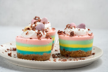 Easter mini cheesecakes with candy eggs and whipped cream.