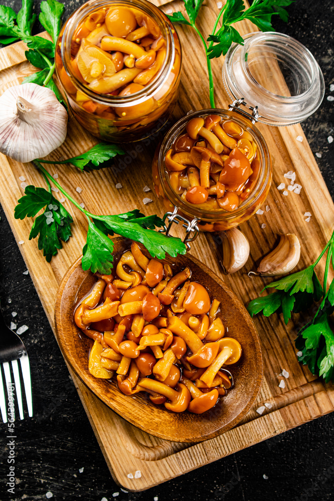 Sticker marinated mushrooms with parsley on a wooden cutting board.