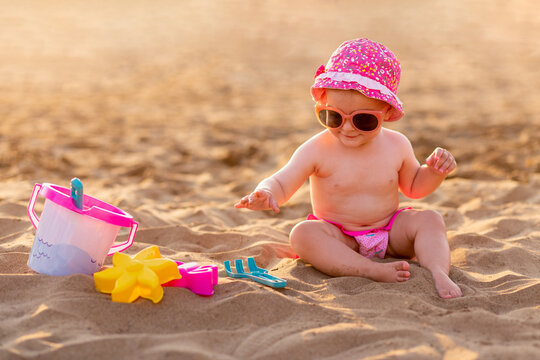 Cute girl playing with beach toys on tropical sandy beach