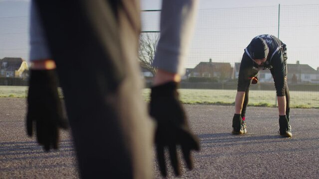 Two men warming and stretching their muscles outdoors in the cold