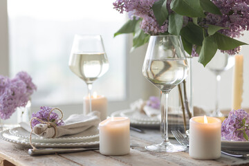 Beautiful table decor for a wedding dinner with a spring blooming lilac flowers. Celebration of a...