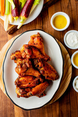 
Chicken wings. Buffalo chicken wings. American cuisine of chicken wings deep-fried, dipped in buffalo sauce made of vinegar,  cayenne hot sauce and butter. Served with celery, carrots, blue cheese.
