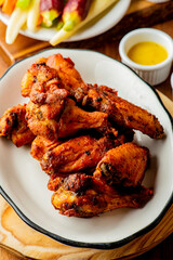 
Chicken wings. Buffalo chicken wings. American cuisine of chicken wings deep-fried, dipped in buffalo sauce made of vinegar,  cayenne hot sauce and butter. Served with celery, carrots, blue cheese.