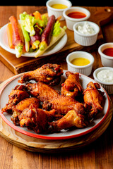 
Chicken wings. Buffalo chicken wings. American cuisine of chicken wings deep-fried, dipped in buffalo sauce made of vinegar,  cayenne hot sauce and butter. Served with celery, carrots, blue cheese.