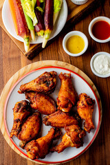 
Chicken wings. Buffalo chicken wings. American cuisine of chicken wings deep-fried, dipped in buffalo sauce made of vinegar,  cayenne hot sauce and butter. Served with celery, carrots, blue cheese.