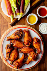 
Chicken wings. Buffalo chicken wings. American cuisine of chicken wings deep-fried, dipped in buffalo sauce made of vinegar,  cayenne hot sauce and butter. Served with celery, carrots, blue cheese.