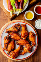 
Chicken wings. Buffalo chicken wings. American cuisine of chicken wings deep-fried, dipped in buffalo sauce made of vinegar,  cayenne hot sauce and butter. Served with celery, carrots, blue cheese.