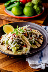 Tacos. Crispy flour and corn tortillas filled with sausage, bacon, beef, cheese, sour cream, salsa and guacamole and served with rice and beans. Classic Tex-Mex or Mexican restaurant entrée favorite.