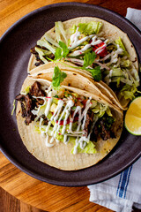 Tacos. Crispy flour and corn tortillas filled with sausage, bacon, beef, cheese, sour cream, salsa and guacamole and served with rice and beans. Classic Tex-Mex or Mexican restaurant entr&eacute;e favorite.