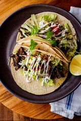Tacos. Crispy flour and corn tortillas filled with sausage, bacon, beef, cheese, sour cream, salsa and guacamole and served with rice and beans. Classic Tex-Mex or Mexican restaurant entrée favorite.