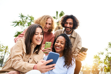 Happy friends using phones and laughing. People and technology having fun. High quality photo