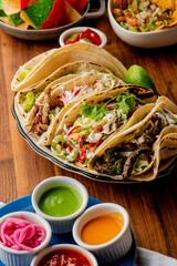 Tacos. Crispy flour and corn tortillas filled with sausage, bacon, beef, cheese, sour cream, salsa and guacamole and served with rice and beans. Classic Tex-Mex or Mexican restaurant entrée favorite.