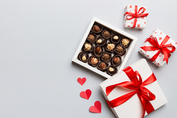 Delicious chocolate pralines in red box for Valentine's Day. Heart shaped box of chocolates top view with copy space