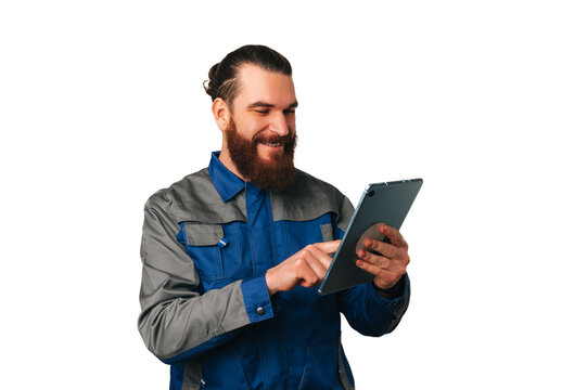 Handsome male engineer wearing blue uniform is working with a digital tablet.