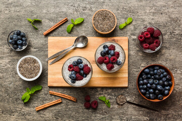Healthy breakfast or morning with chia seeds vanilla pudding raspberry and blueberry berries on table background, vegetarian food, diet and health concept. Chia pudding with raspberry and blueberry