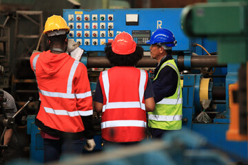  Supervisor Consults Young Engineer Working with big machine