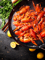 Boiled crayfish in a pot with parsley and lemon. 