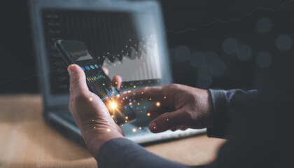 Businessman using application on smartphone and laptop computer to analyze information in stock trading, Index trading data chart investment growth chart, Cryptocurrency financial market analysis.