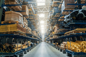 Modern distribution warehouse interior with many goods in boxes on shelves.