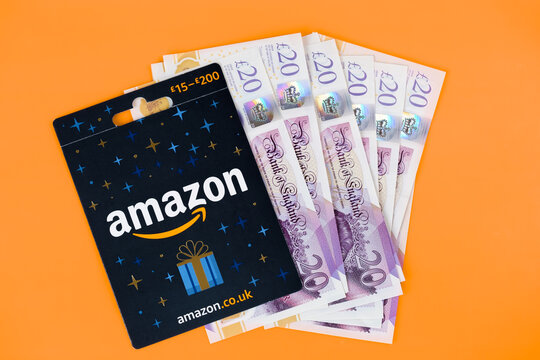 Amazon Gift Card placed on pile of cash. Stafford, United Kingdom, January 24, 2023