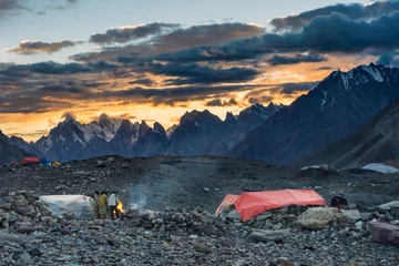 Papier Peint photo autocollant K2 Pakistani porters around campfire at Concordia during sunset, K2 base camp trek, Karakoram, Pakistan