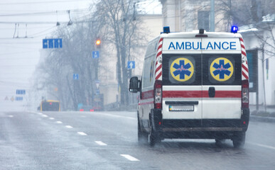 An ambulance car is driving along the city street at high speed. © CreativeSuburb