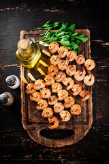 Fragrant grilled shrimp on a cutting board with oil and parsley. 
