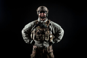 Naklejka premium portrait of a positive soldier in a military uniform, a commando is smiling on a black background, a member of elite troops